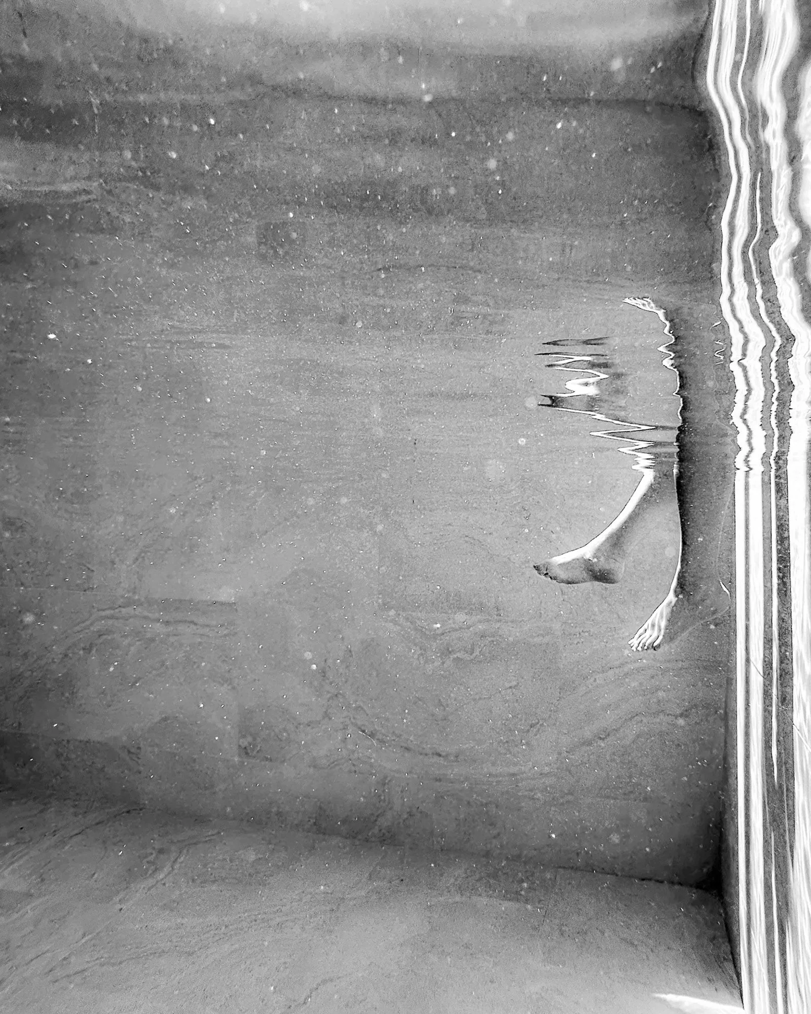 Black and white overhead abstract of a figure floating in water, abstract photography by Hector's Eye