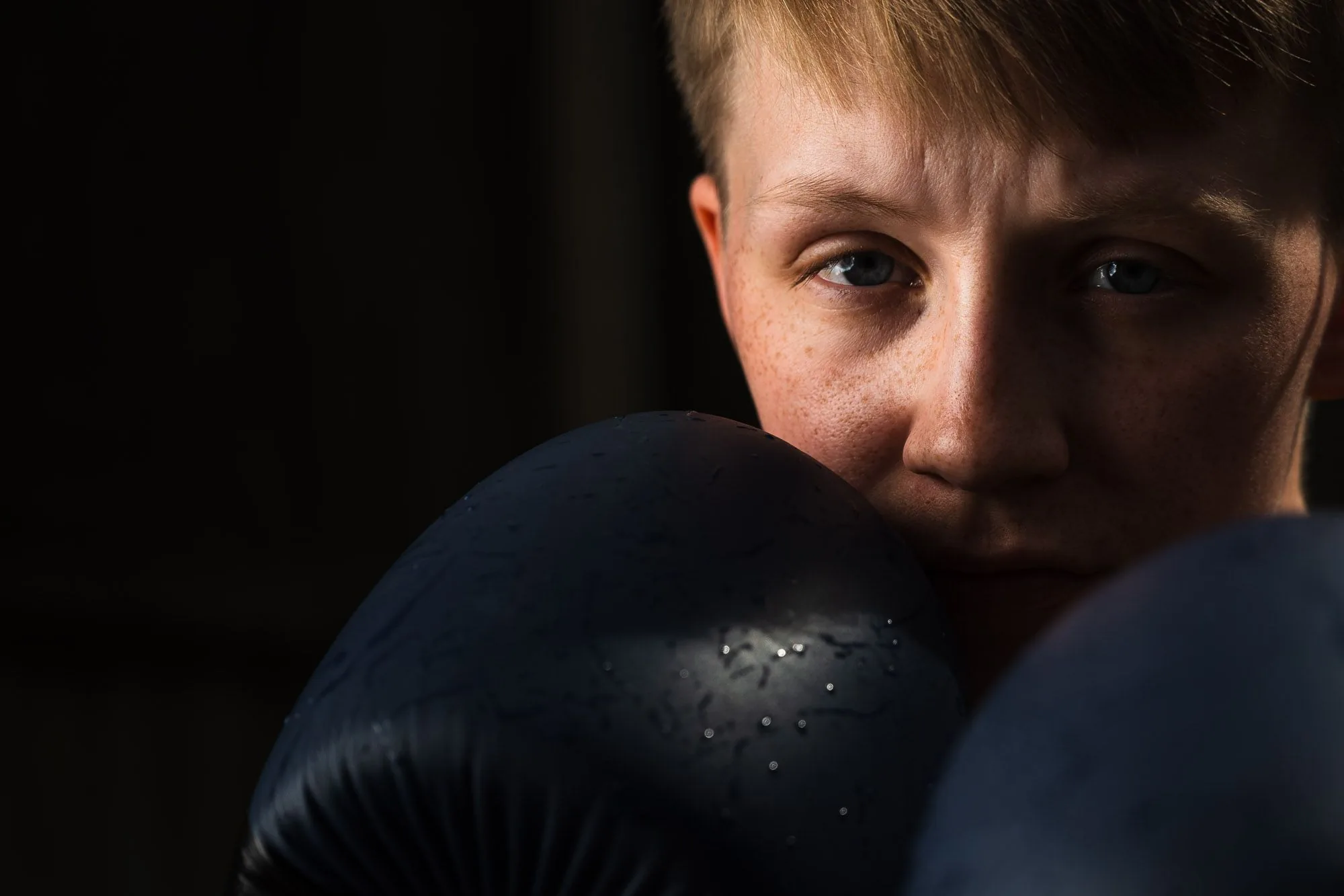 Close-up portrait of a boxer wearing gloves, editorial portrait photography by Hector's Eye