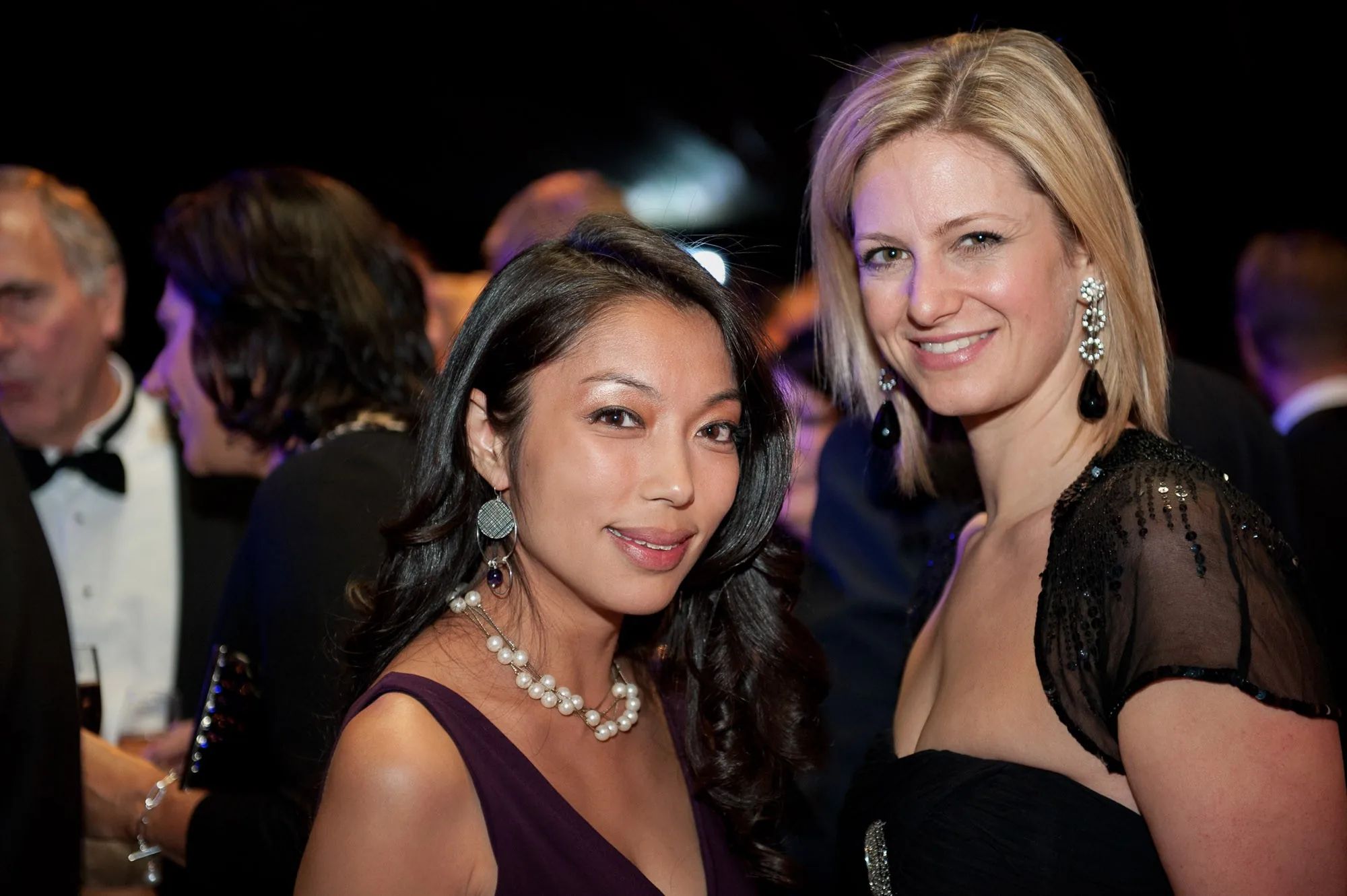 Two guests smiling together at a corporate gala reception, event photography by Hector's Eye