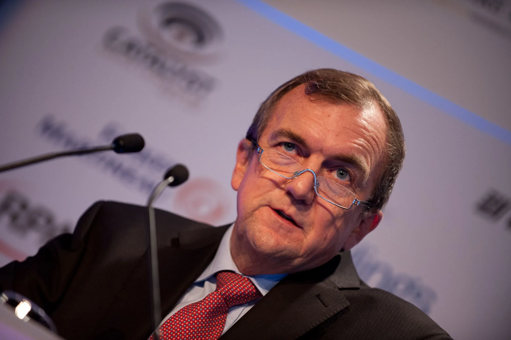 Speaker addressing fellow panellists at a corporate conference panel discussion, event photography by Hector's Eye