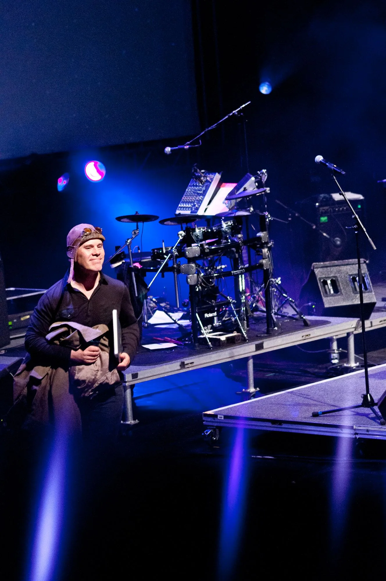 Musician performing at a keyboard rig on stage under blue lighting, live music photography by Hector's Eye